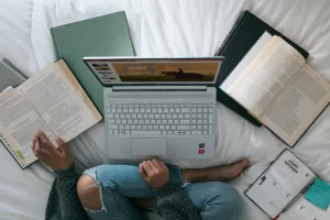 girl-using-computer-and-books-simultaneously