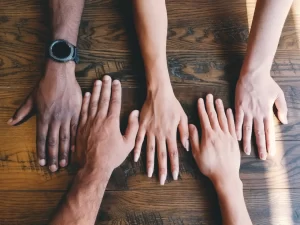 multiple-hands-laid-on-table