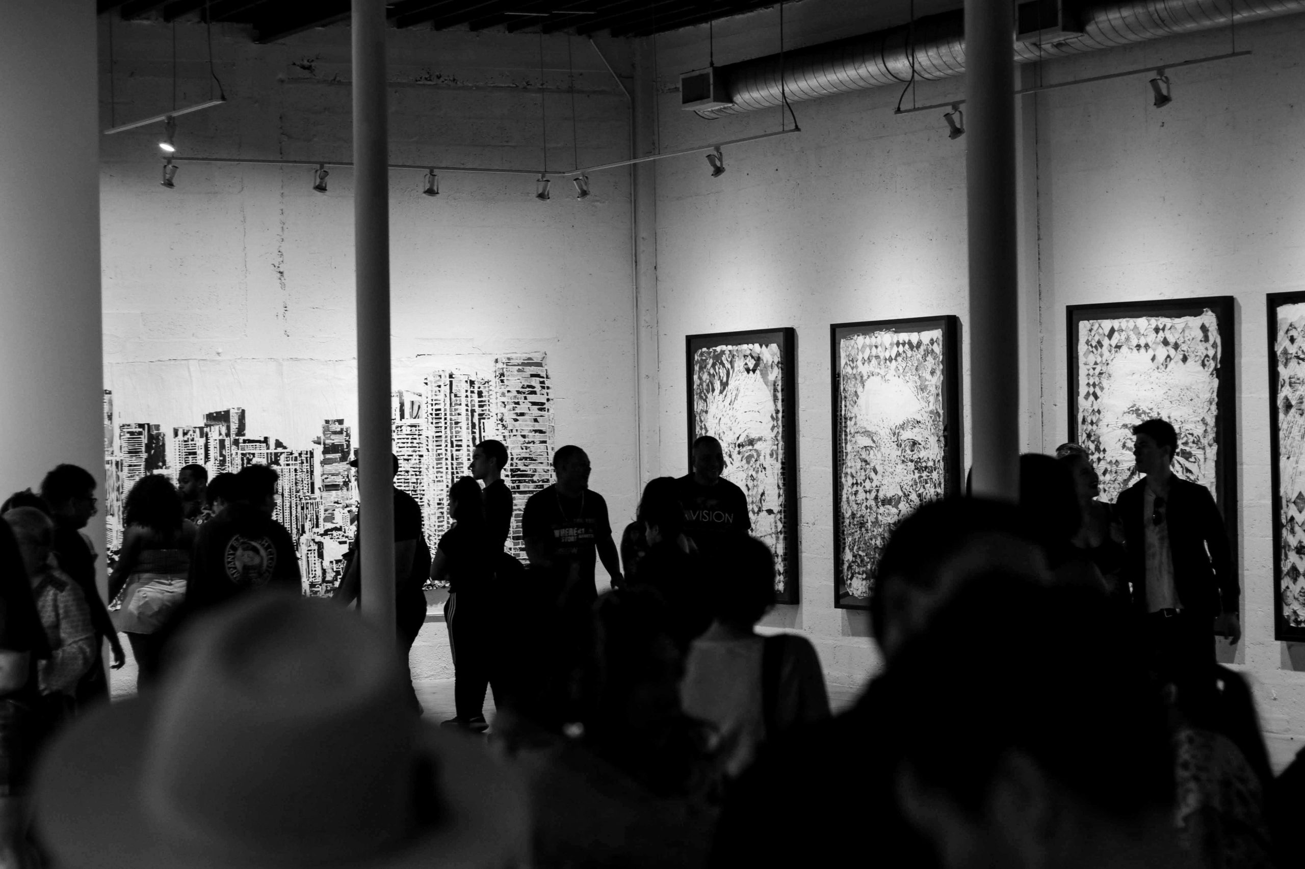 people looking to paintings on the wall