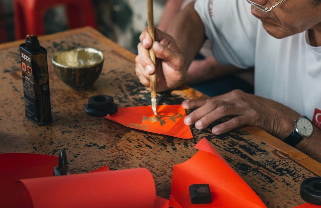 men drawing on a red paper